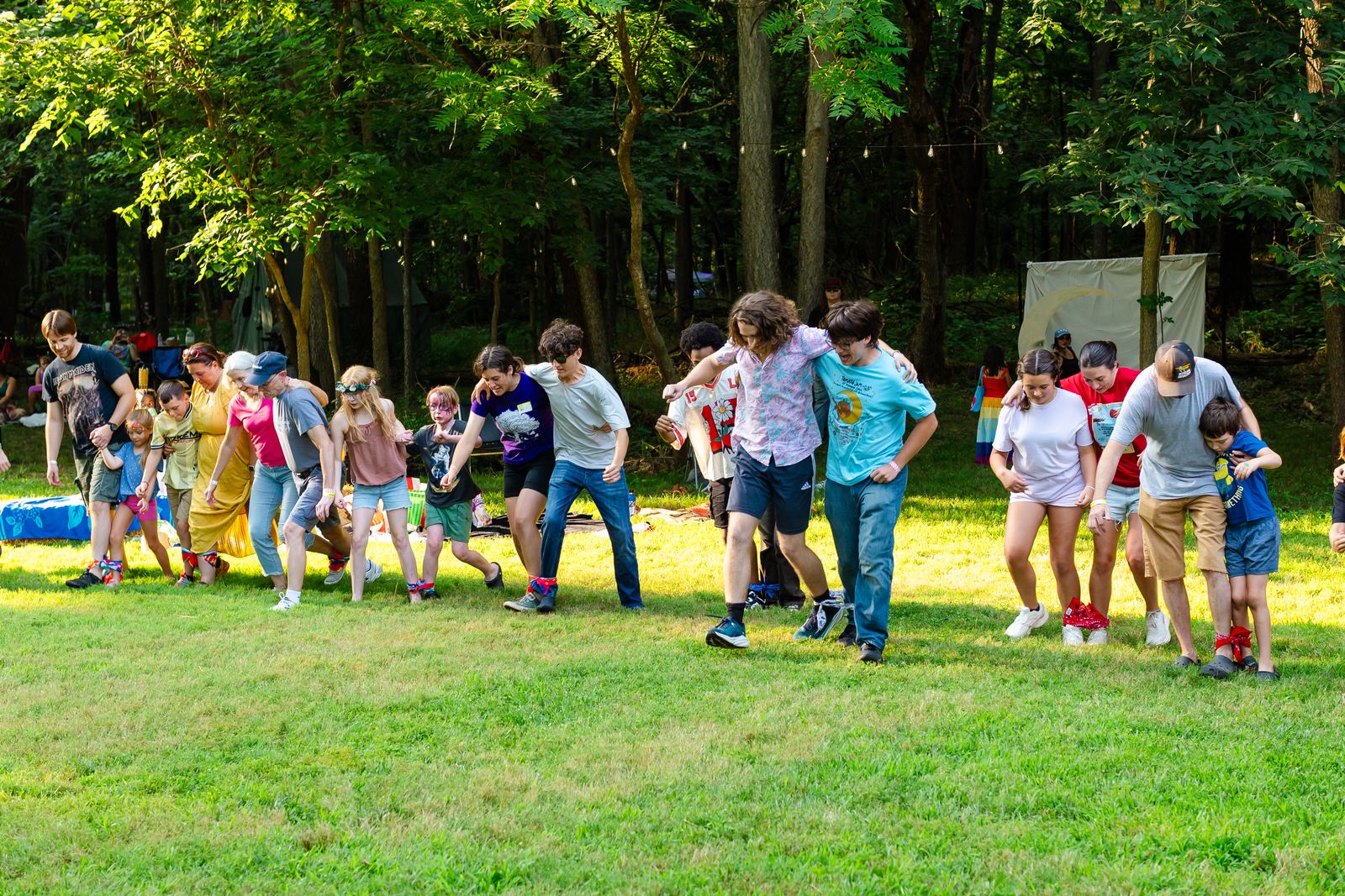 Pairs with ankles tied together lurching forward at the start of the three-legged race at Tomato Jam
