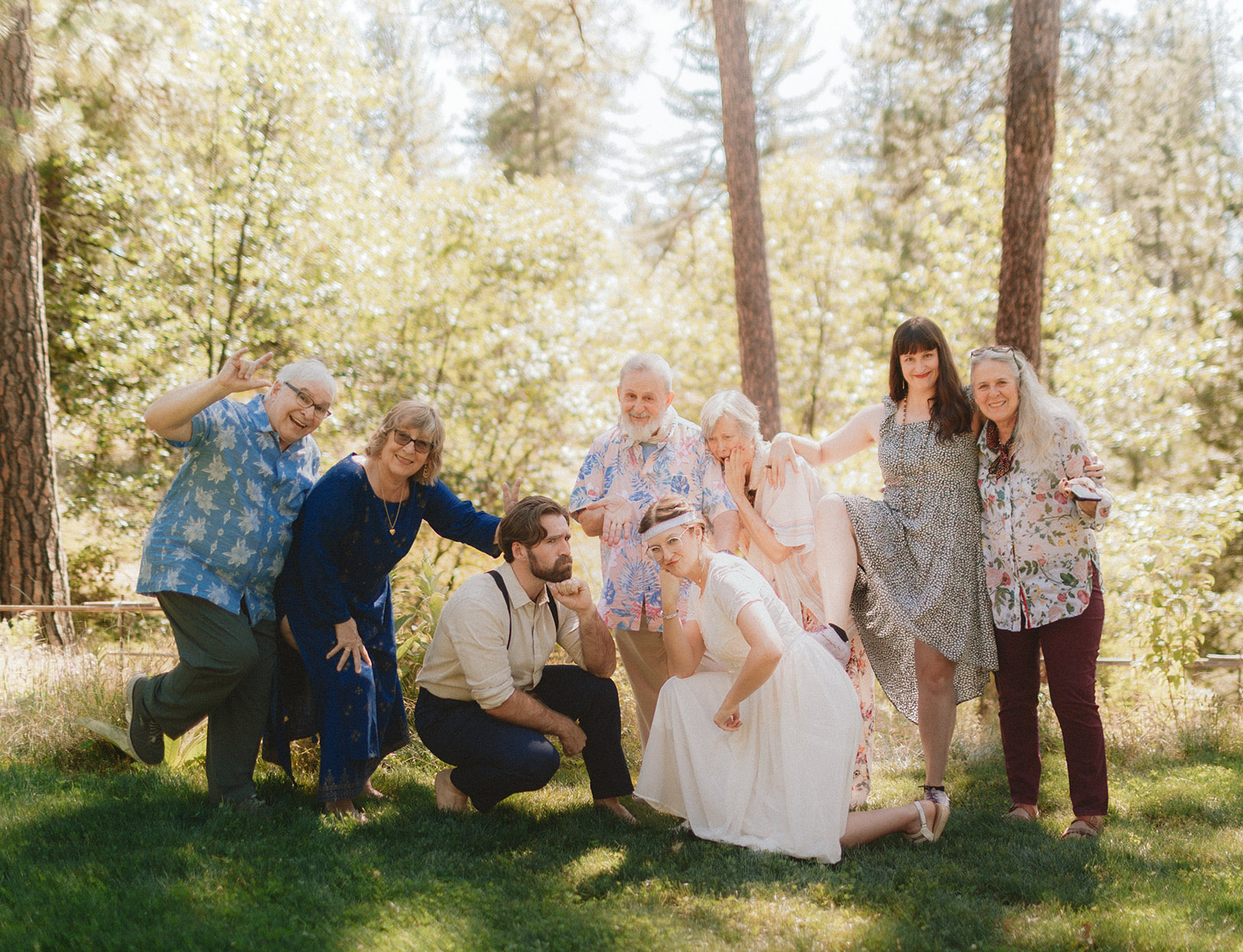 Guests in eclectic, colorful outfits striking playful poses at a California wedding