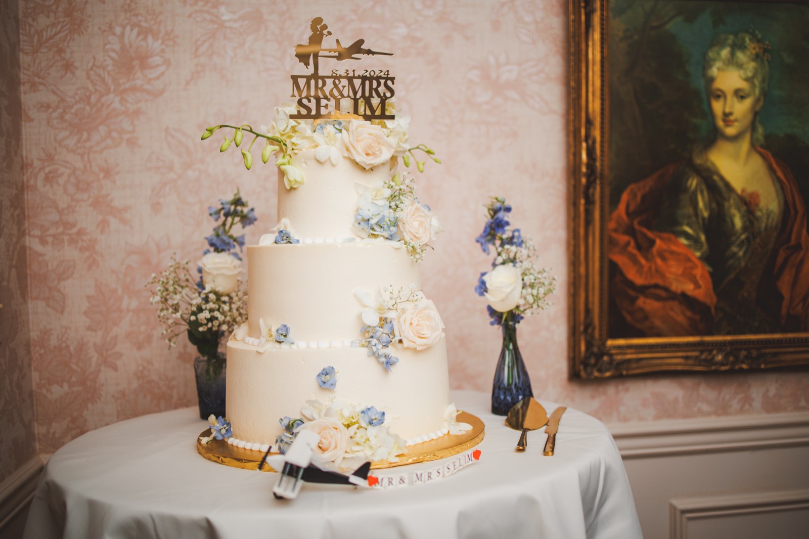 A wedding cake topped with an airplane, cold-spark fireworks behind it