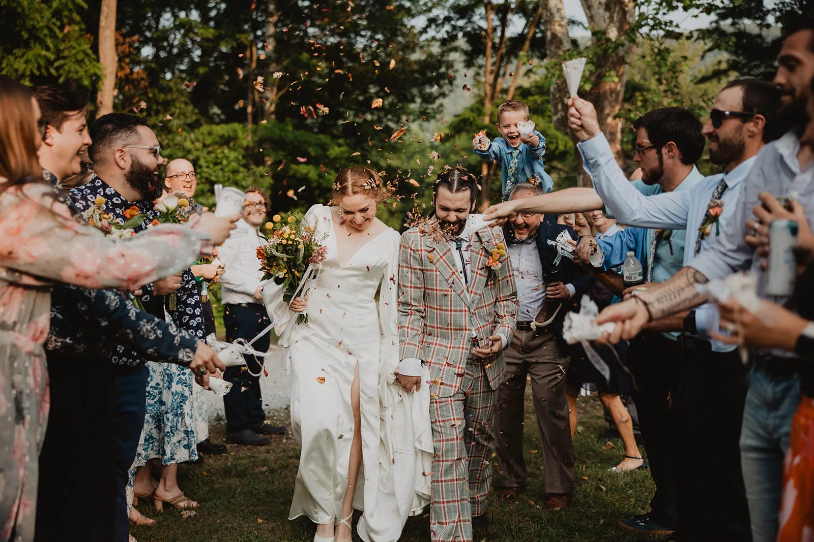 Sadie and Aaron walking through guests throwing petals after their wedding ceremony